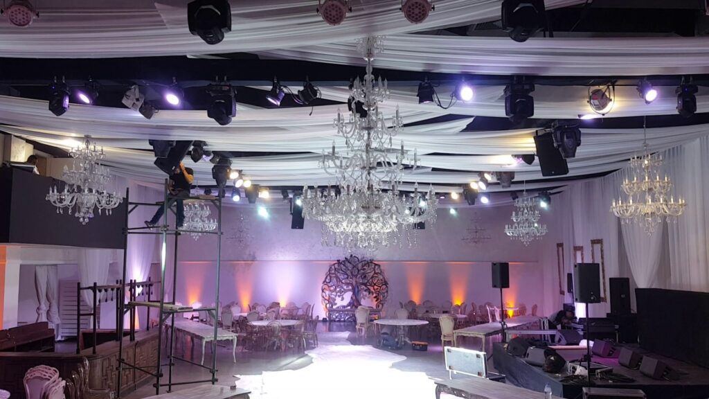 a stage with a white ceiling and chandelier