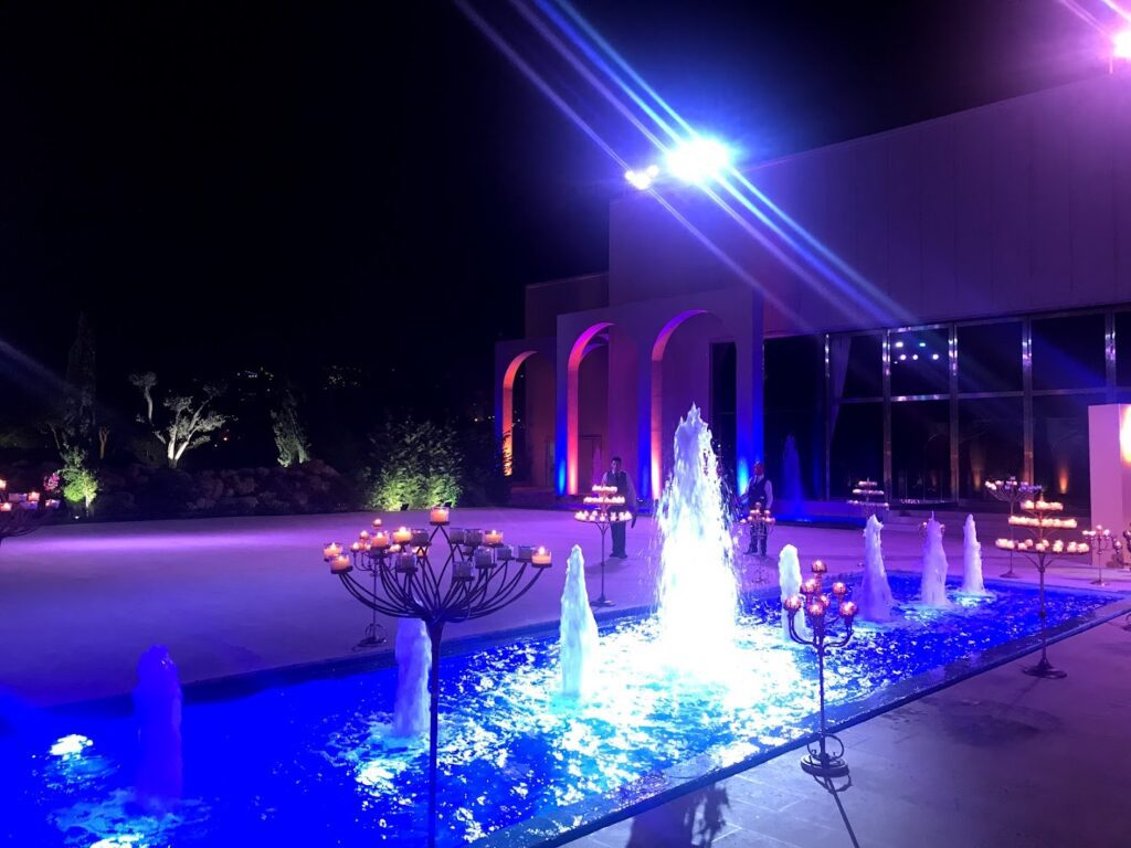 a fountain with lights in front of a building