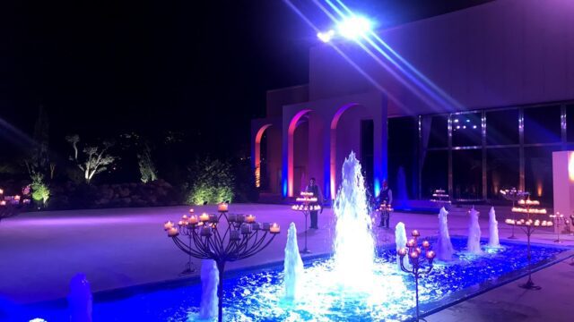 a fountain with lights in front of a building