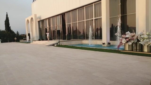 a building with a fountain and a man standing in front of it