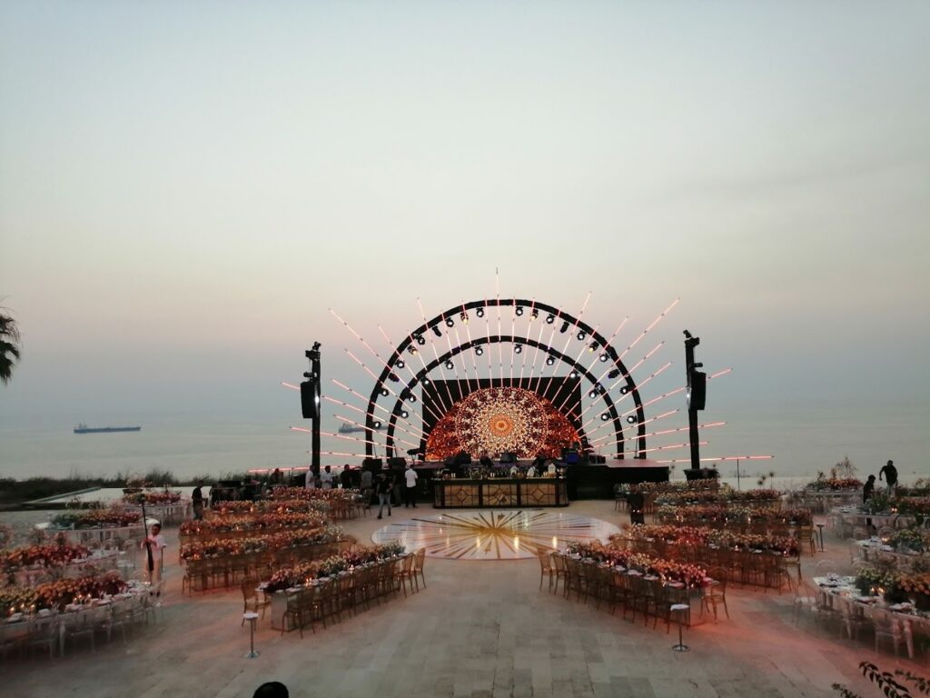 a stage with tables and chairs on a beach