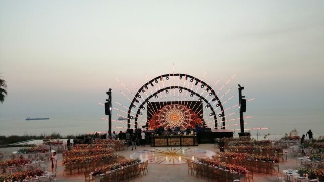 a stage with tables and chairs on a beach