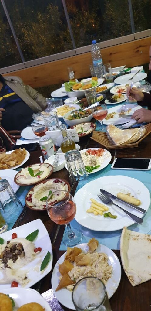 a group of people sitting at a table with plates of food