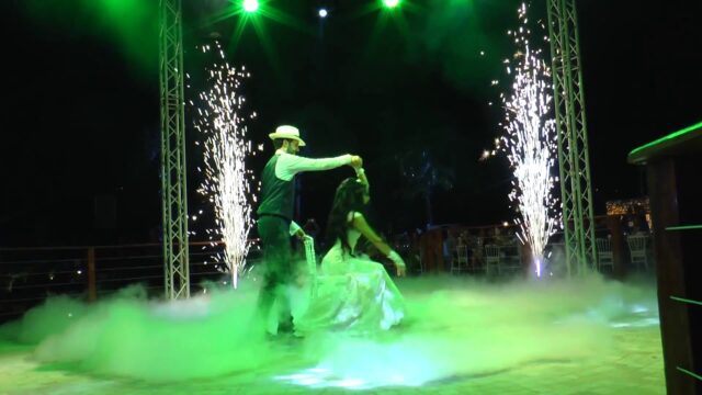 a man and woman dancing in a smokey area