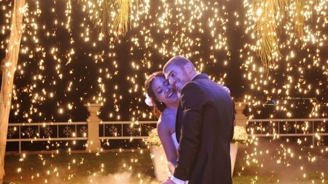 a man and woman in front of a firework display