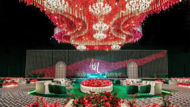 a large room with red flowers and a chandelier