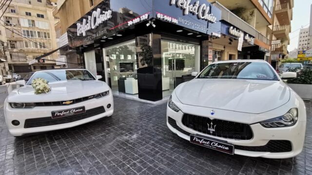 a couple of white cars parked outside a building