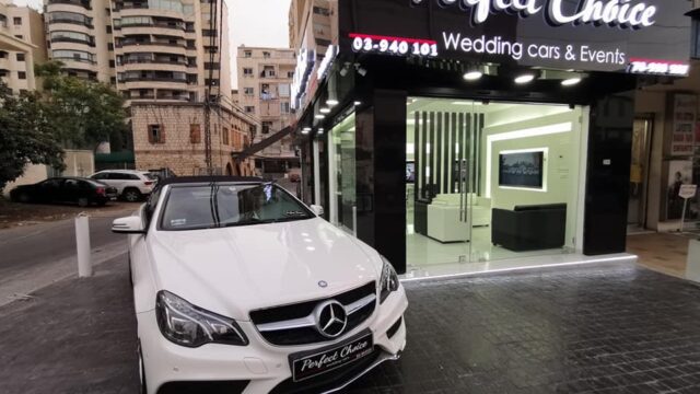 a white car parked in front of a store