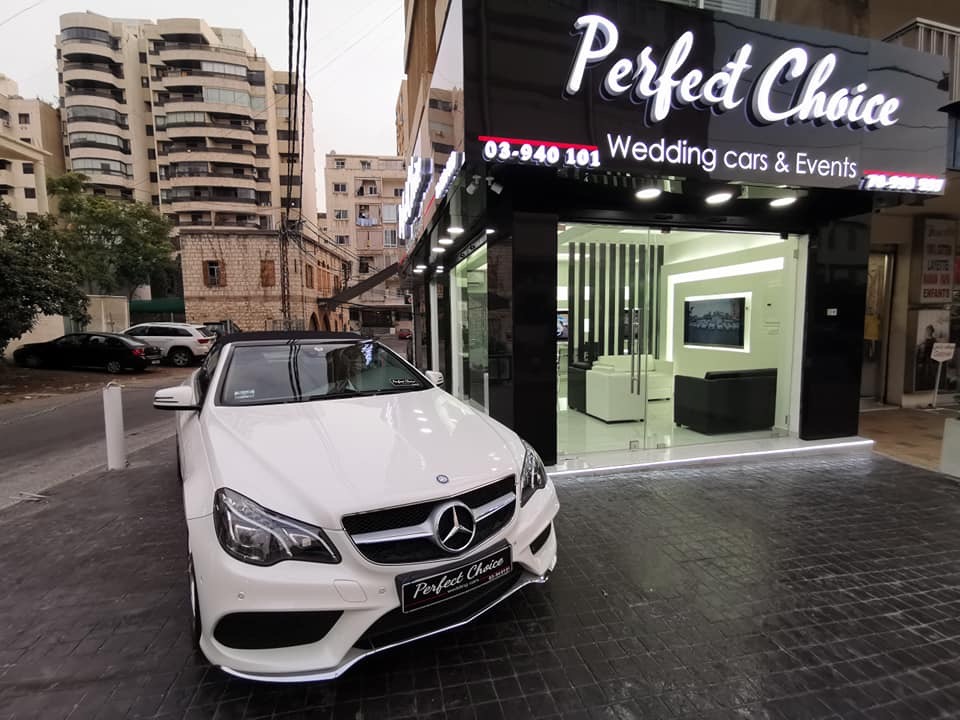 a white car parked in front of a store