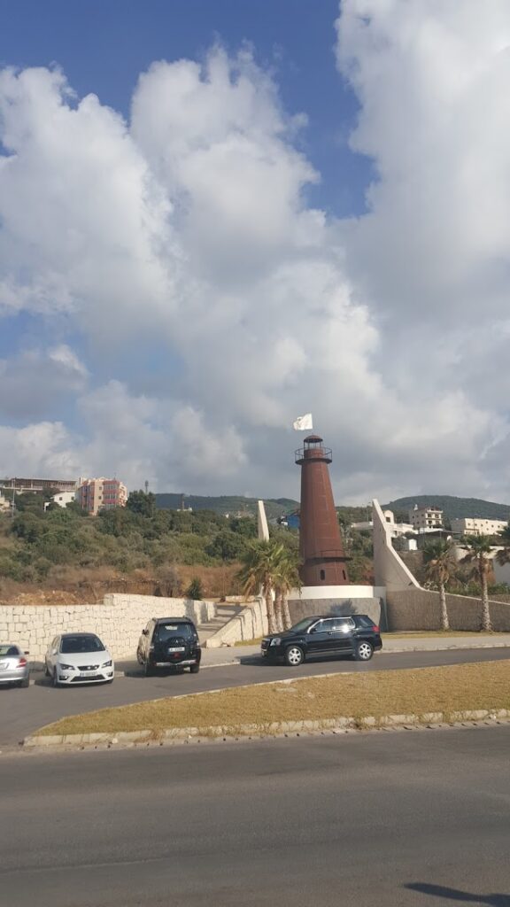 a lighthouse with cars parked in front of it