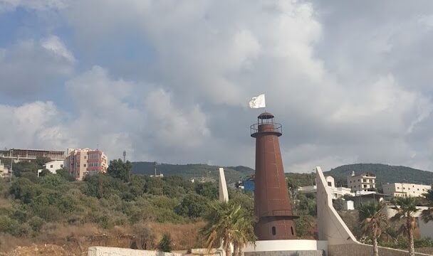 a lighthouse with cars parked in front of it