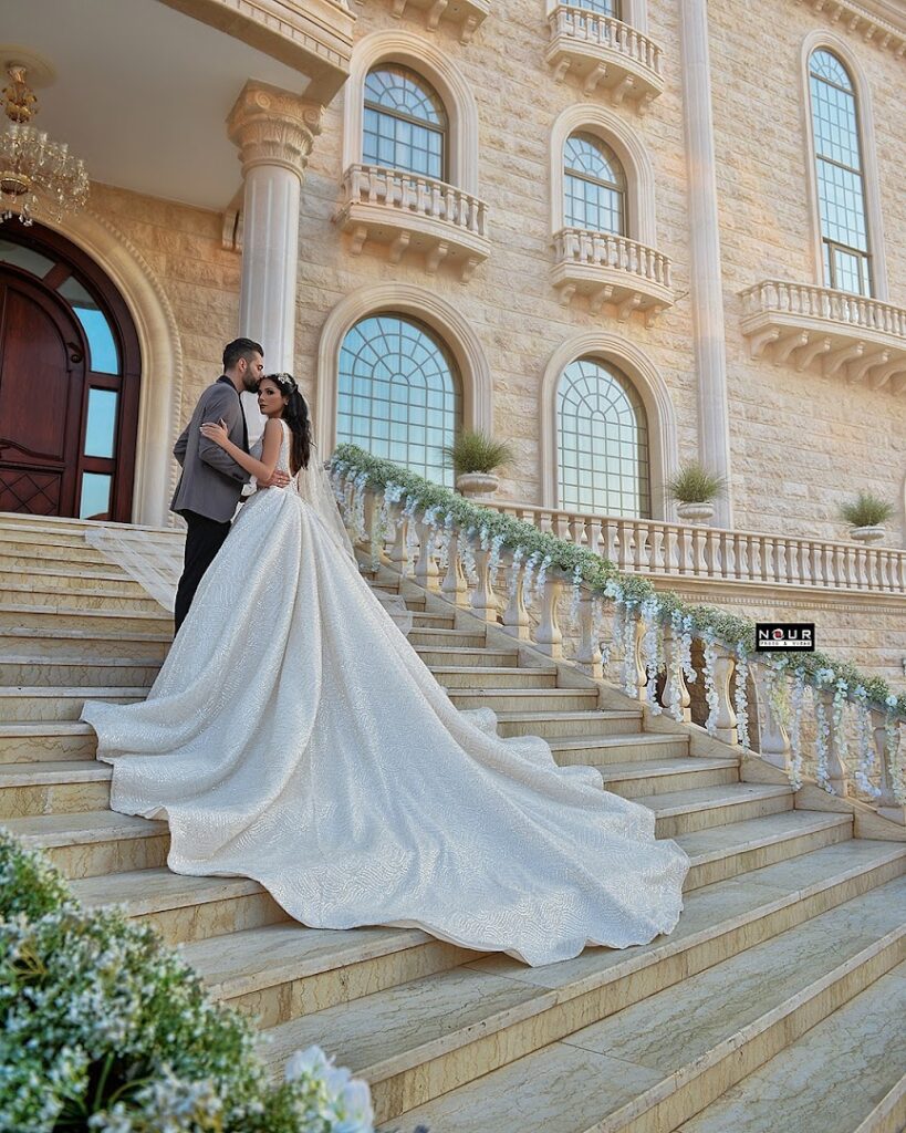 a man and woman in a wedding dress on stairs