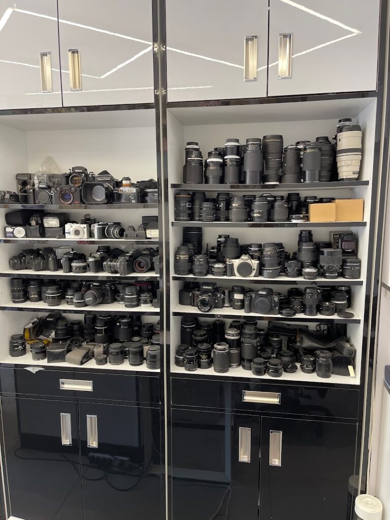 A large collection of Photo Paladium cameras on shelves.