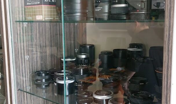 A glass cabinet with camera lenses showcasing the latest collection of "Photo palladium" equipment.