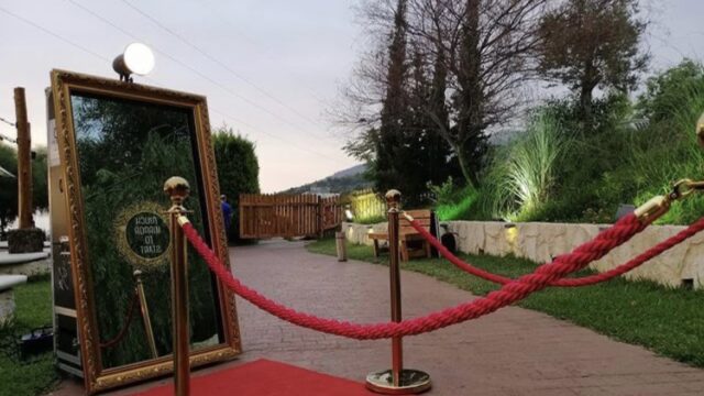 A red carpet with a rope around it leads the way towards the glamorous "PicMe Photobooth".