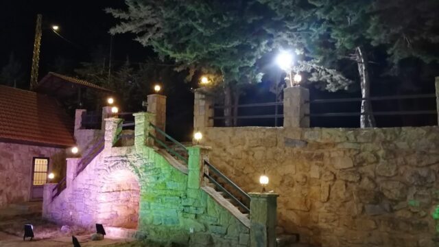 a stone wall with lights and a bridge