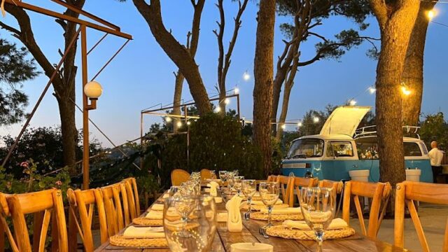 a table set for dinner with wine glasses and plates on it