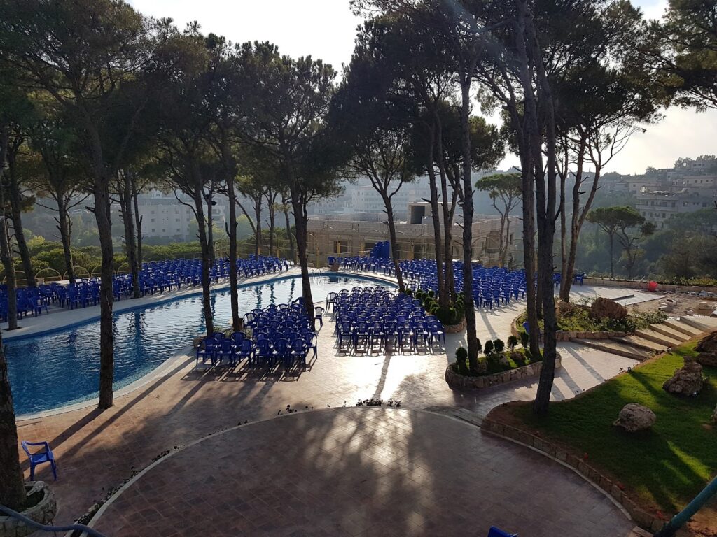 a pool with blue chairs and trees