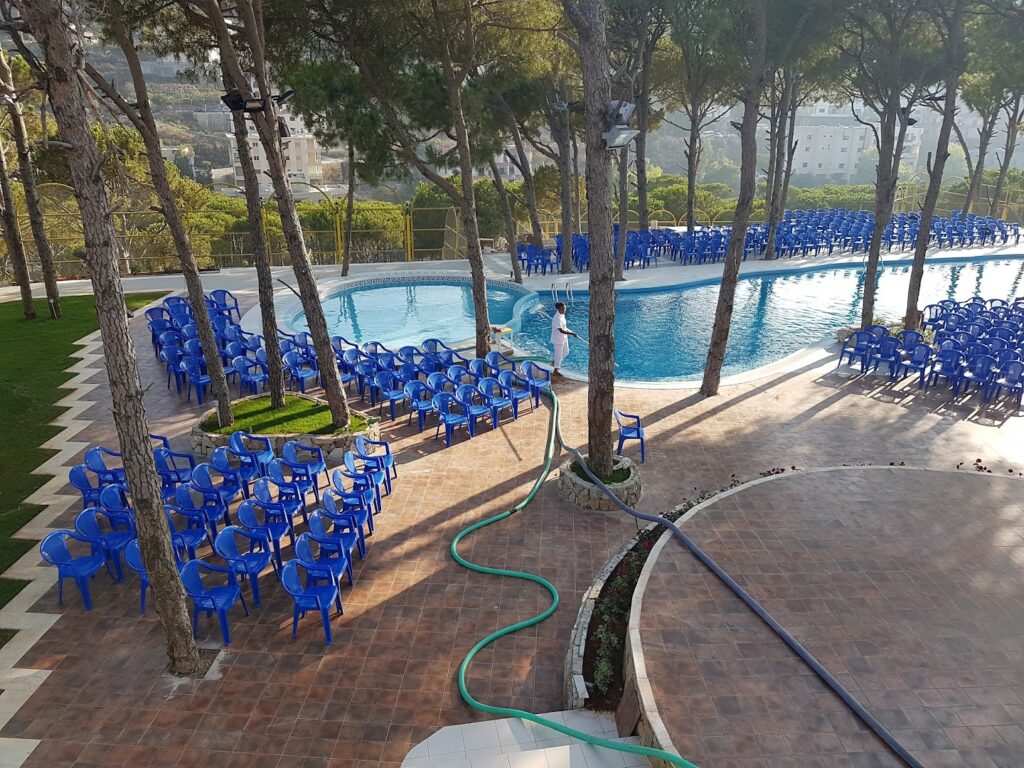 a pool with blue chairs and trees