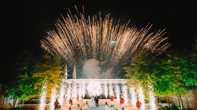 a group of people standing on stairs with fireworks in the background