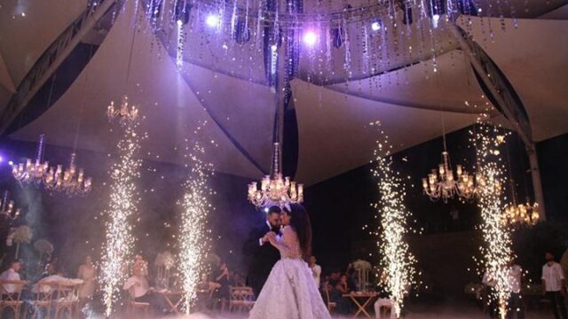 a man and woman dancing under a white tent