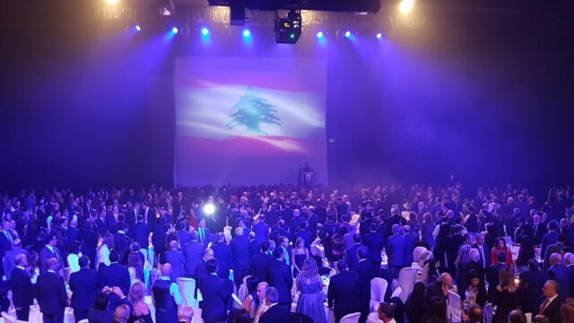 a large group of people in a room with a large screen