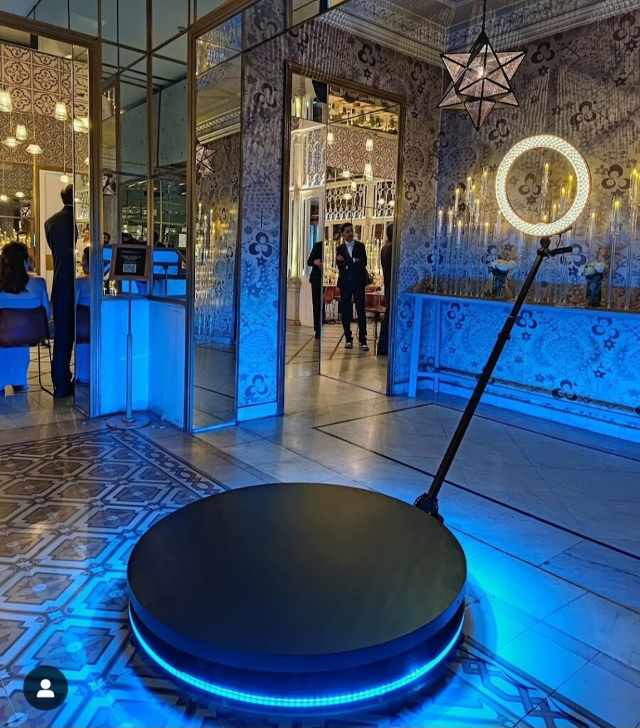 In a PuzzleBooth, there is a circular object with mesmerizing lights on it, captivating the attention of the people in the room.