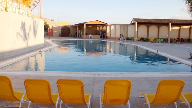 a pool with yellow chairs