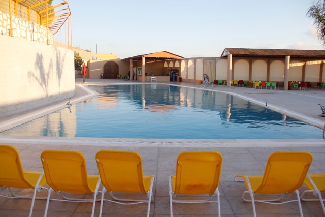 a pool with yellow chairs