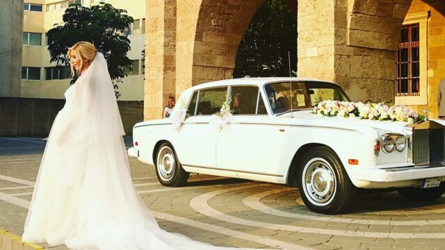 a woman in a wedding dress next to a car