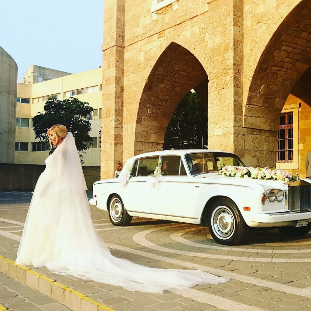 a woman in a wedding dress and a white car