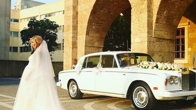 a woman in a wedding dress and a white car