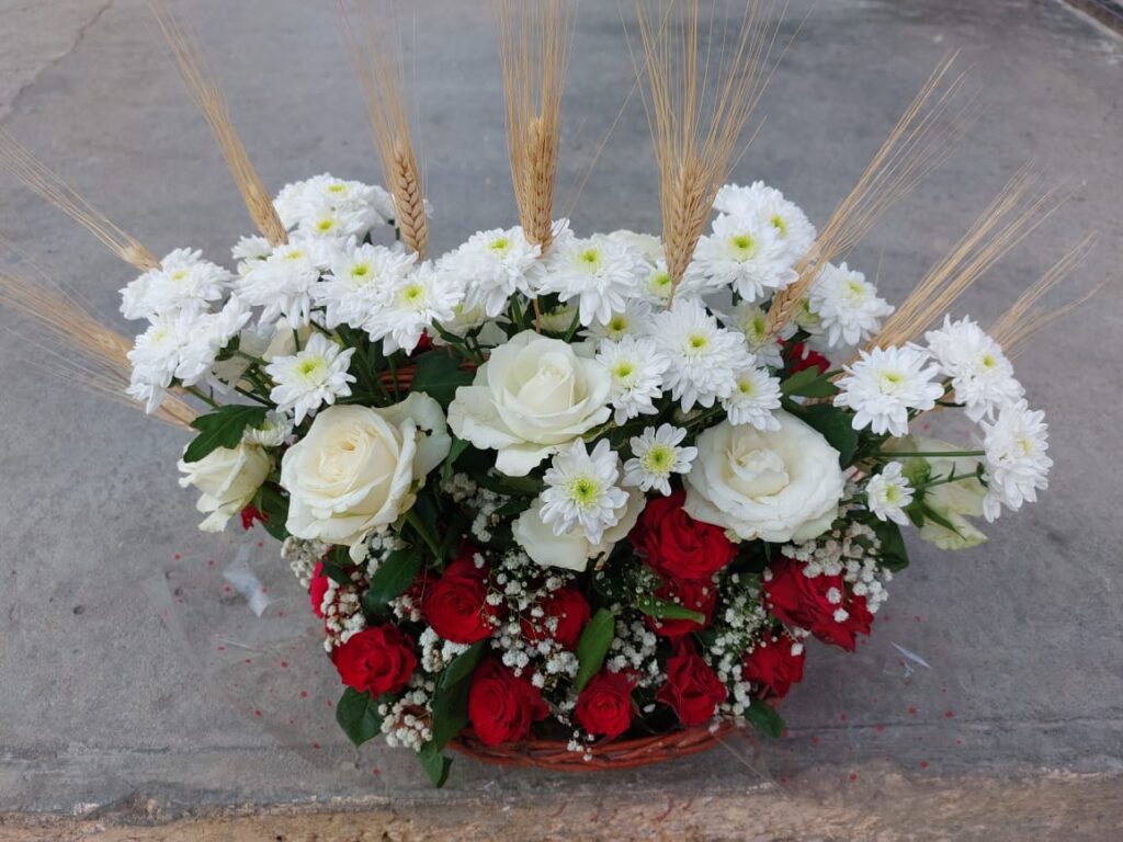 a basket of flowers and wheat