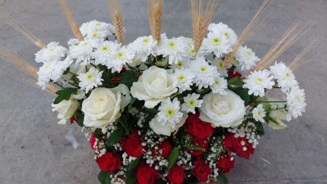 a basket of flowers and wheat