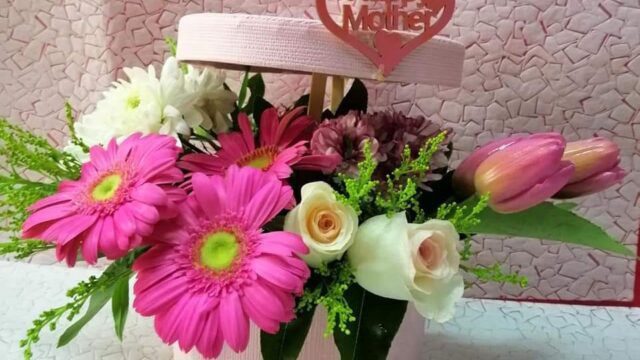 a pink flower arrangement in a box