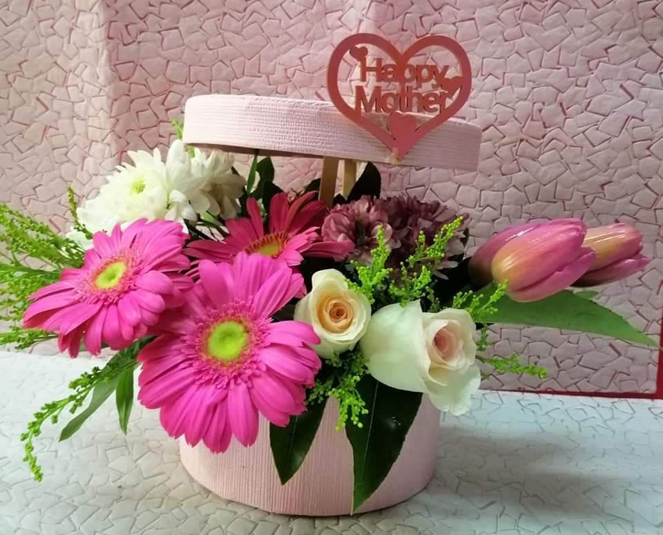 a pink flower arrangement in a box