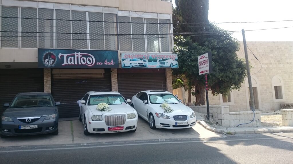 a couple of white cars parked in front of a building