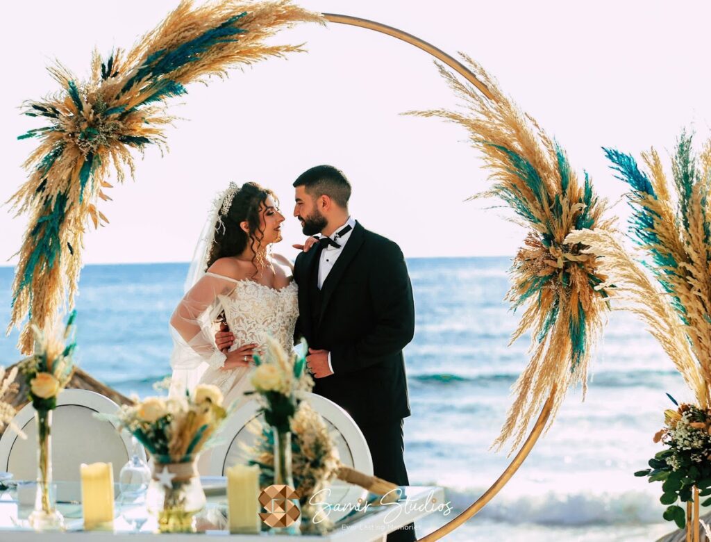 a man and woman kissing under a circular arch with wheat and plants