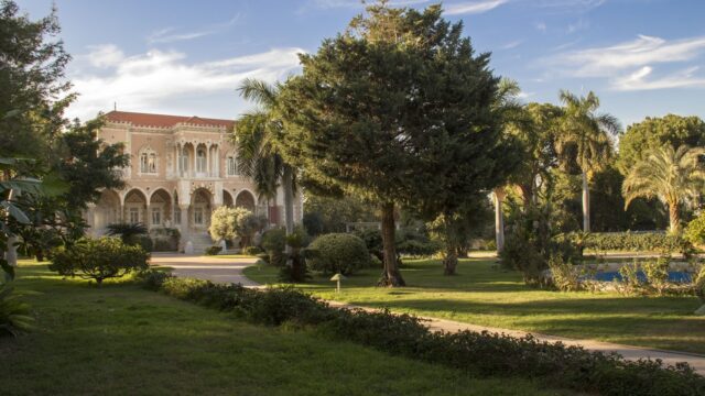 a large building with trees and grass