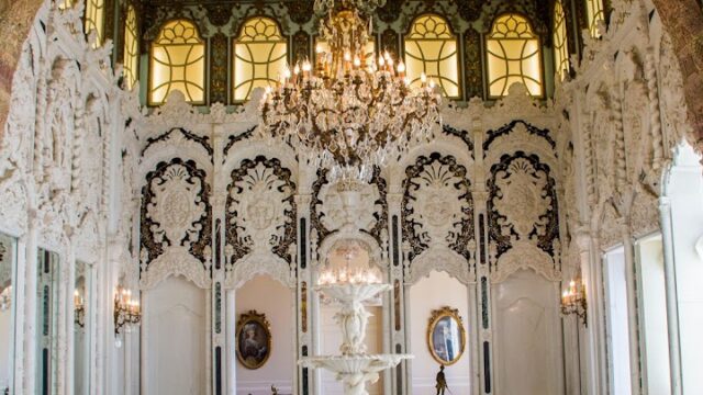 a white room with a fountain and chandelier