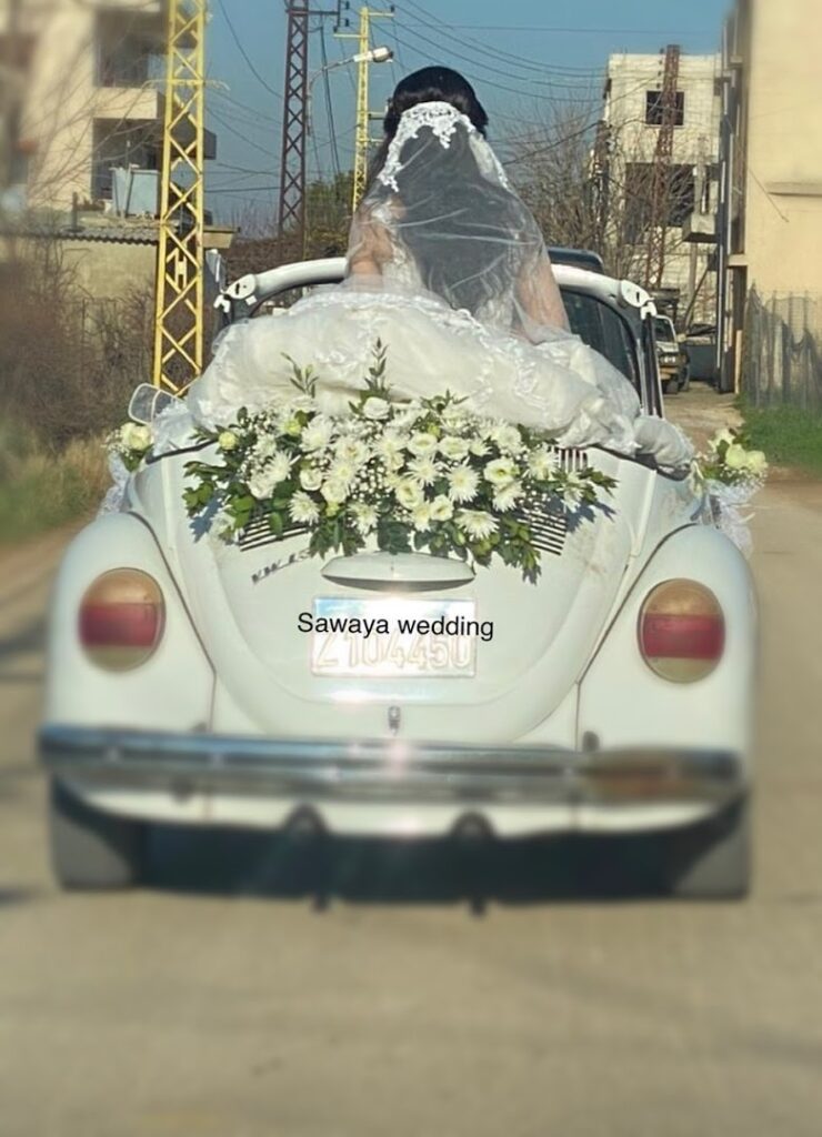 a bride in a wedding dress on a car