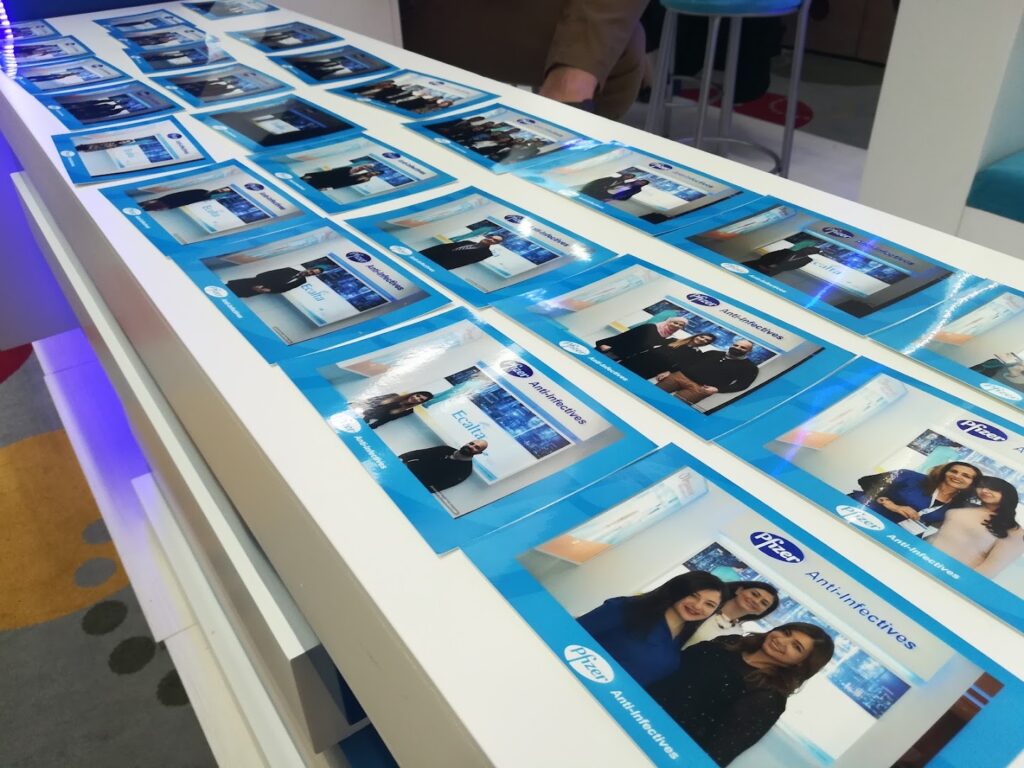 A table with blue and white photos featuring the "Selfiesbox Photobooth".