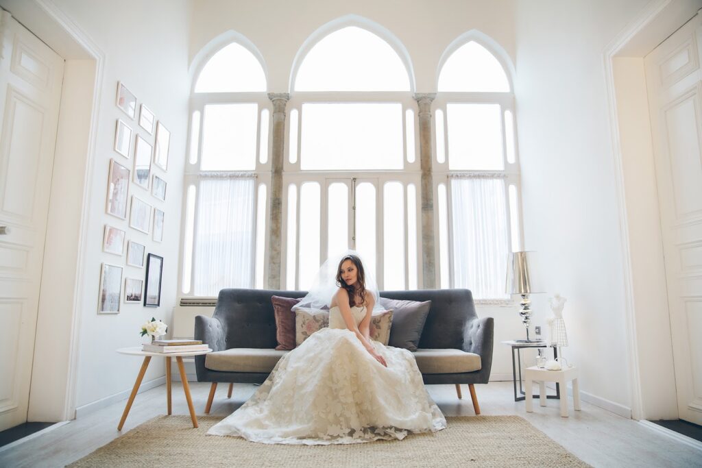 a woman in a wedding dress sitting on a couch