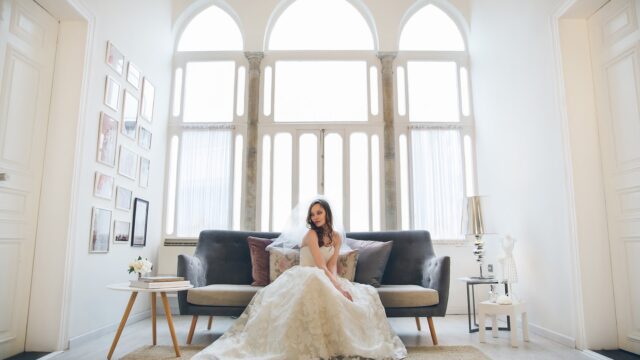 a woman in a wedding dress sitting on a couch