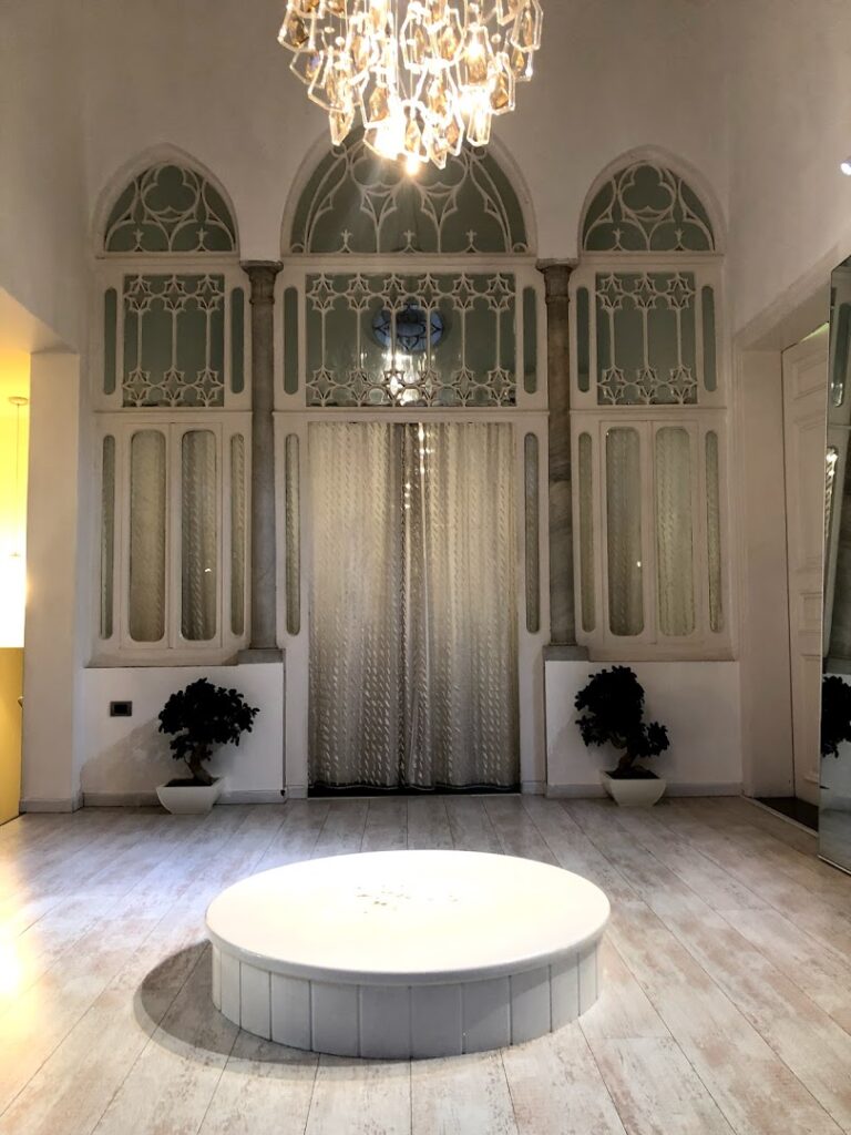 a room with a round white table and a chandelier