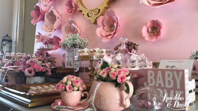 a table with pink flowers and cups