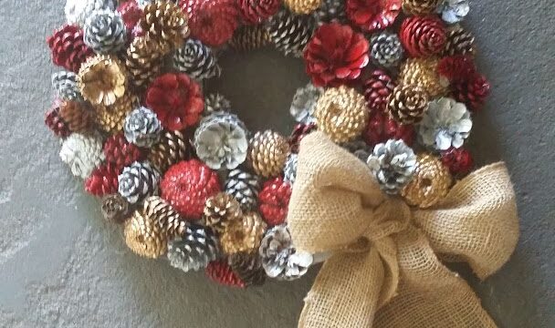 a wreath made of pine cones and a burlap bow