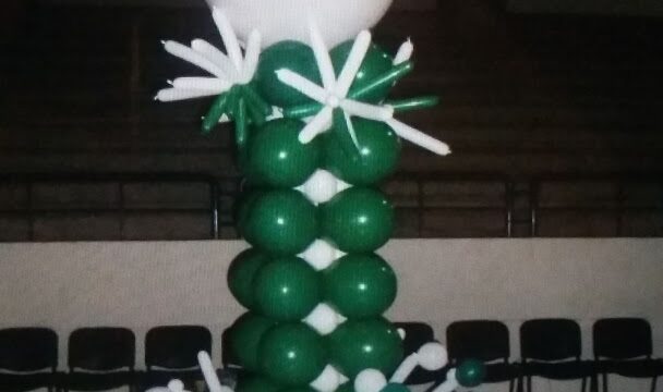 a balloon sculpture with a white ball and green flowers