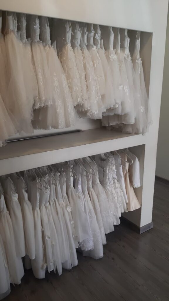 a shelf with white dresses on it
