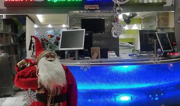 a santa claus standing in front of a store